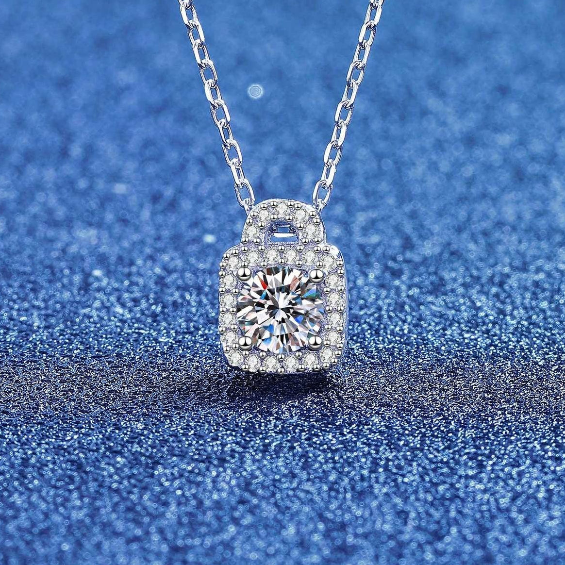 Close-up of a round moissanite lock pendant necklace with pavé halo