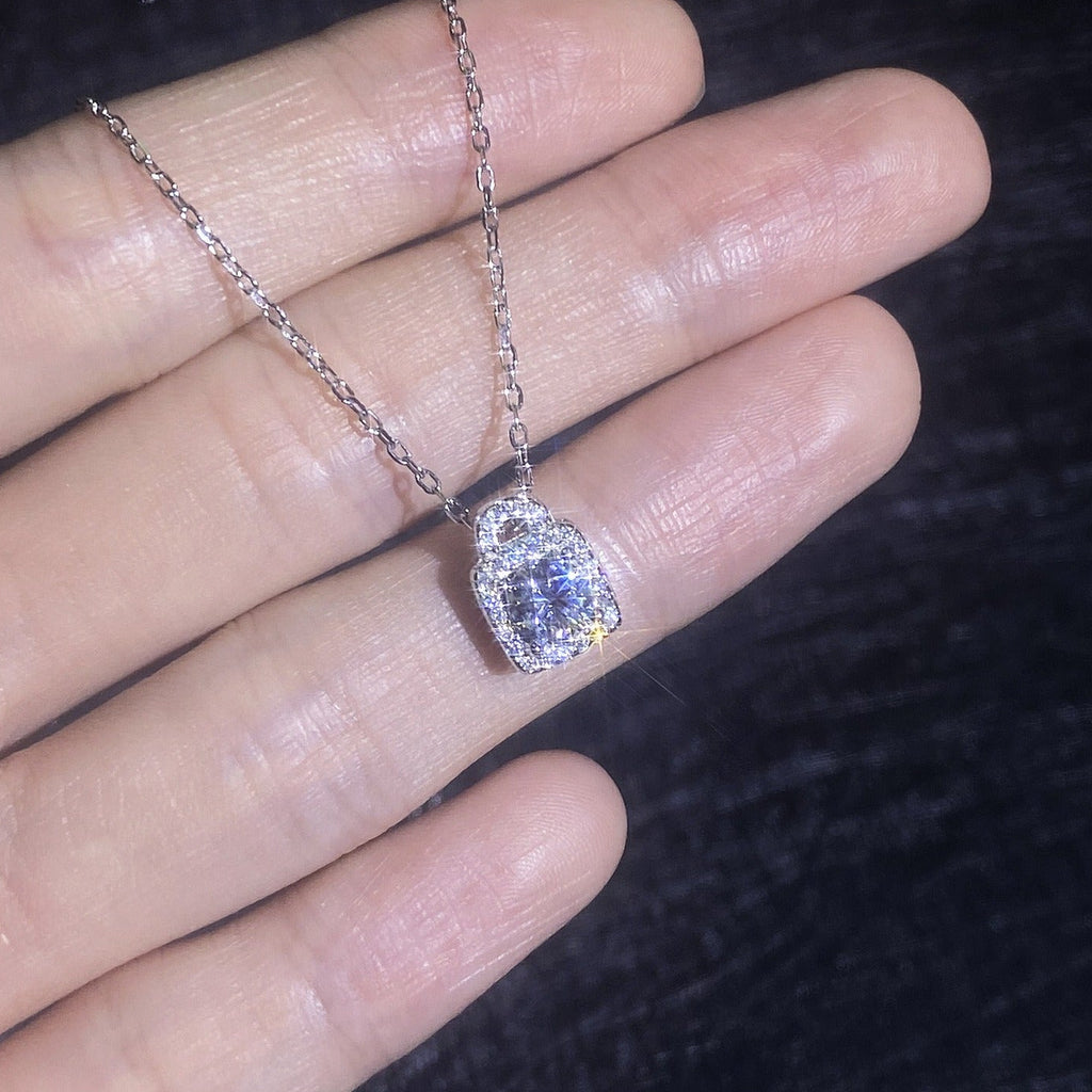 Moissanite lock pendant necklace shown in hand with delicate chain