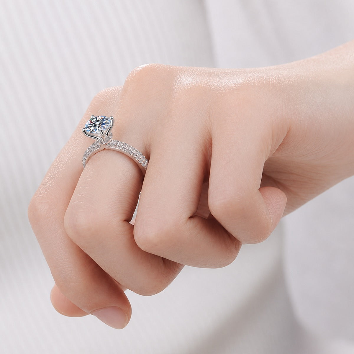 Round Moissanite Side Stone Engagement Ring with CZ worn on hand to show scale, band width, and ring profile