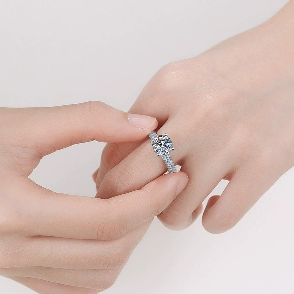 Round Moissanite Side Stone Engagement Ring with CZ worn on hand to show scale, band width, and ring profile
