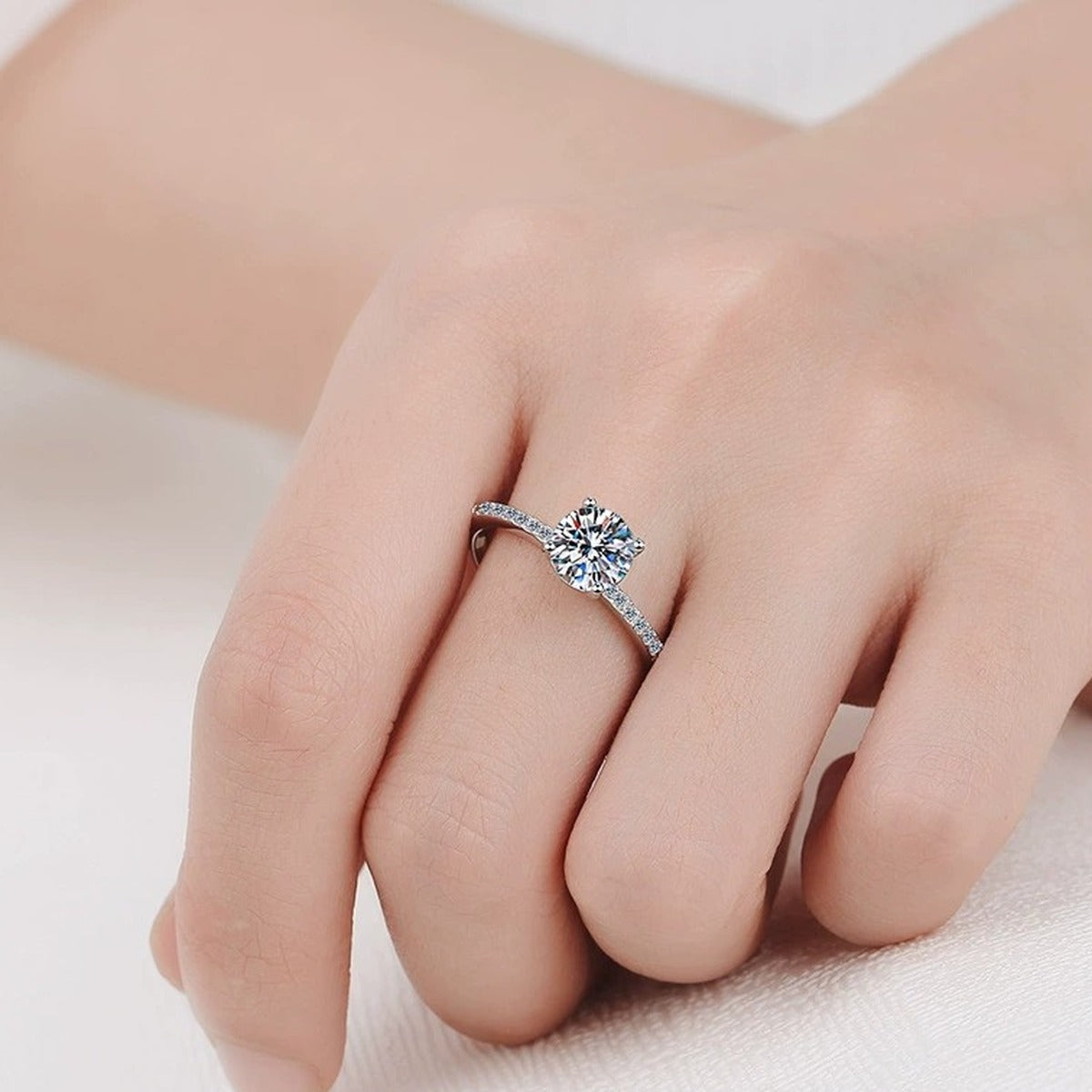 Round Moissanite Side Stone Ring with CZ worn on hand to show scale, band width, and ring profile