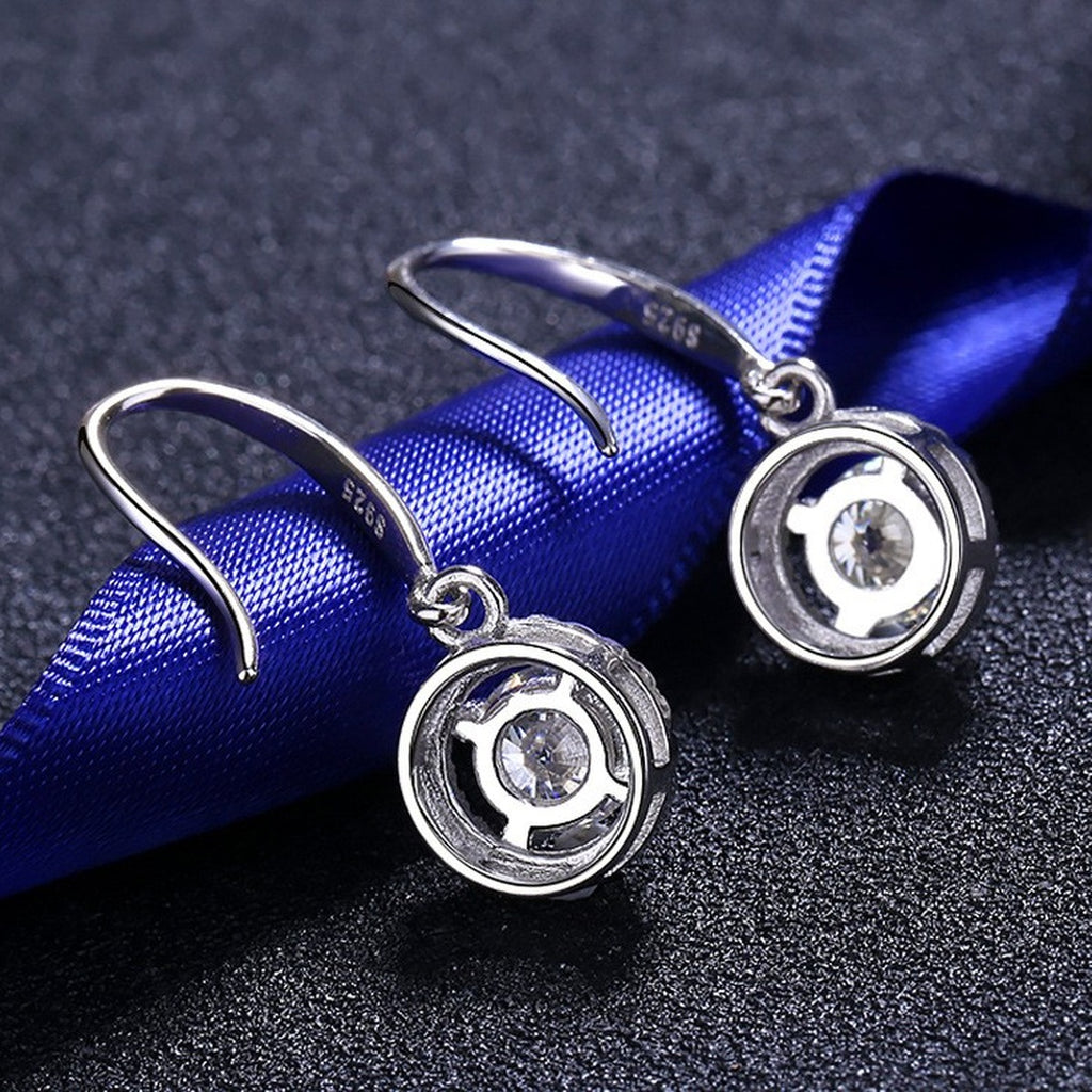 Round Halo Moissanite Hook Dangle Earrings with CZ in Rhodium-Plated S925 Sterling Silver on blue-green fabric showing front detail