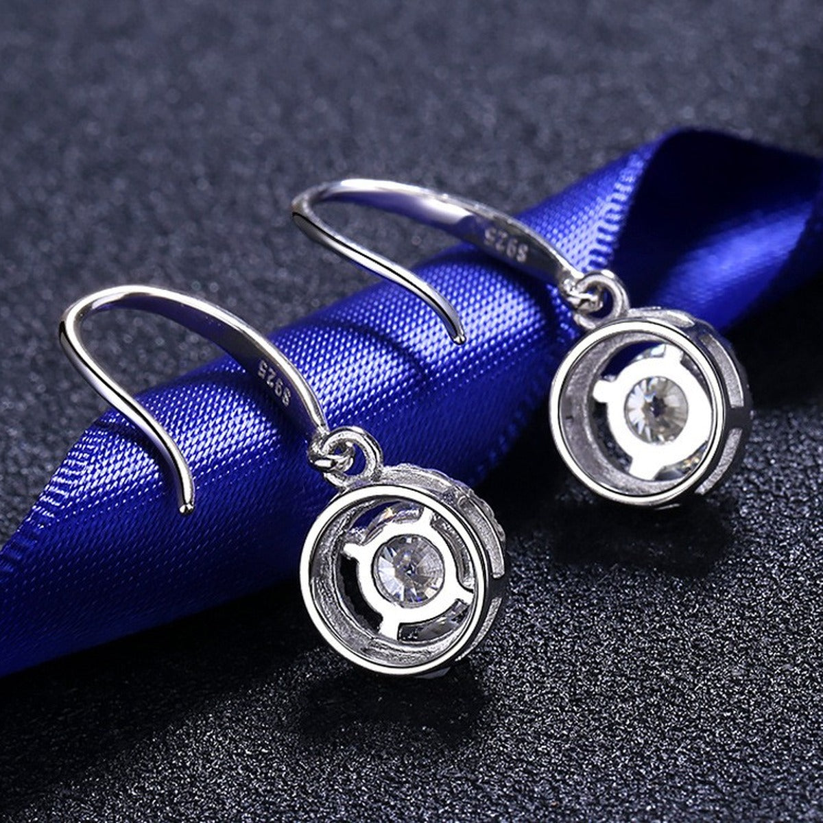 Round Halo Moissanite Hook Dangle Earrings with CZ in Rhodium-Plated S925 Sterling Silver on blue-green fabric showing front detail