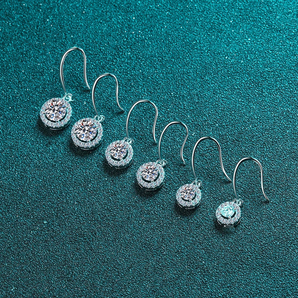 Round Halo Moissanite Hook Dangle Earrings with CZ in Rhodium-Plated S925 Sterling Silver on blue-green fabric showing full pair comparison