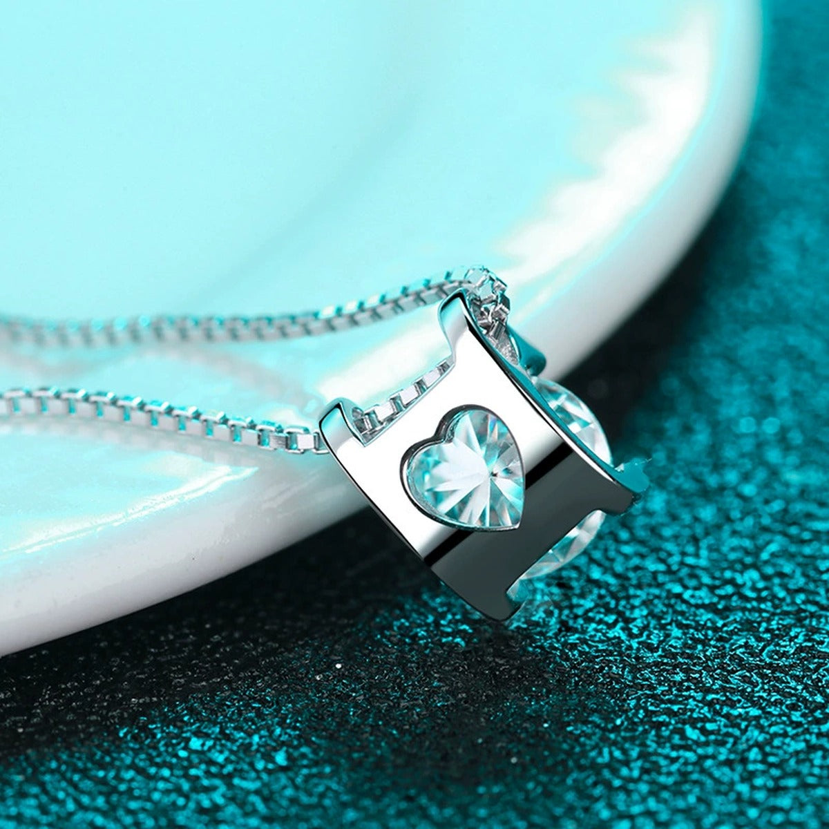 Solitaire and Cross Round Moissanite Pendant Necklace in Rhodium-Plated S925 sterling silver blue display scene showing chain and stone layout
