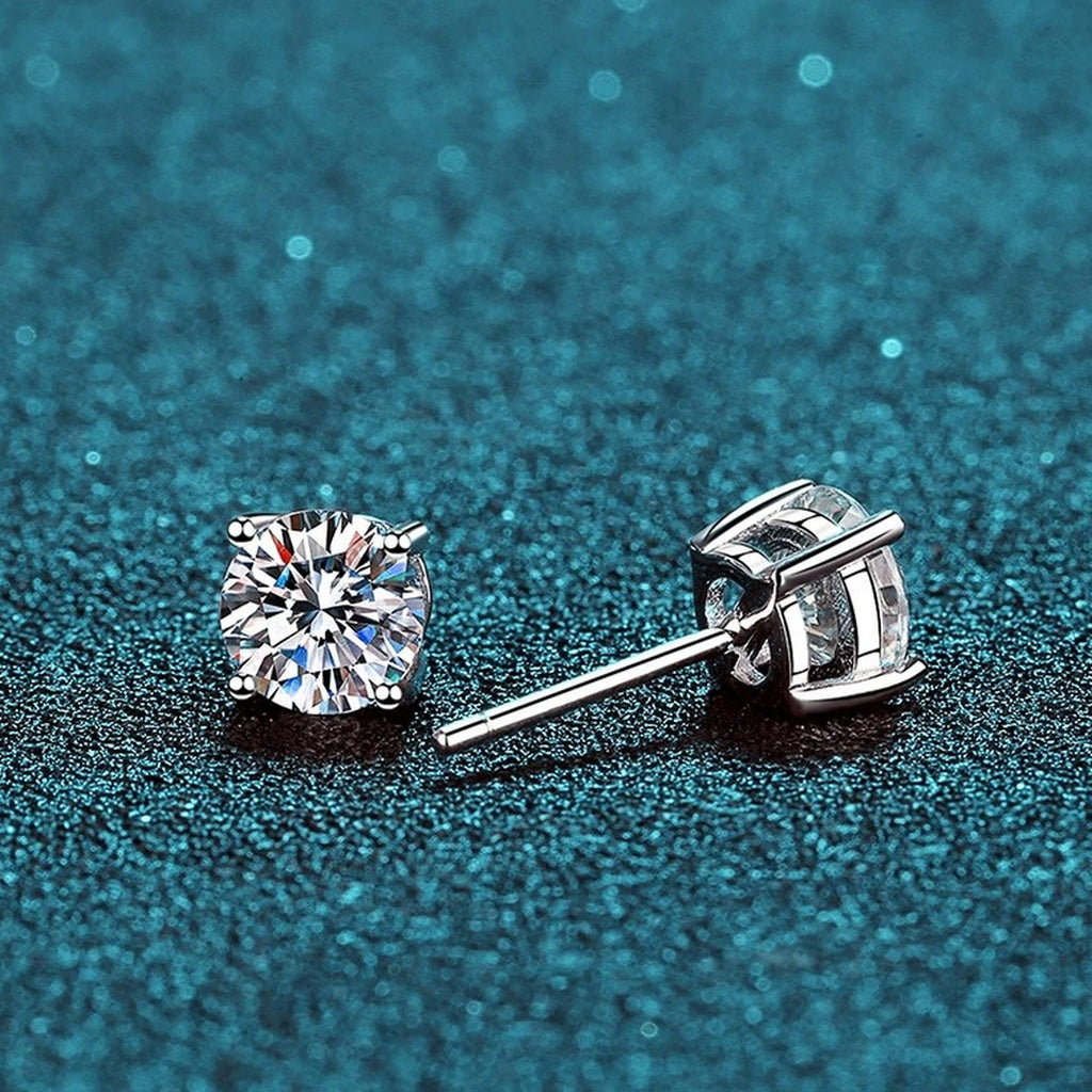 Classic Round Moissanite Stud Earrings in Rhodium-Plated S925 Sterling Silver on blue-green fabric showing front detail