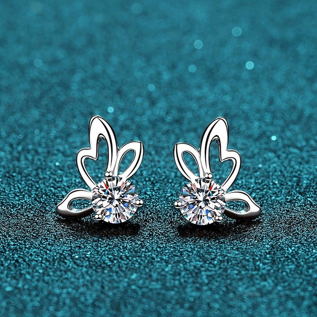 Butterfly Moissanite Stud Earrings in Rhodium-Plated S925 Sterling Silver on blue-green fabric showing front detail