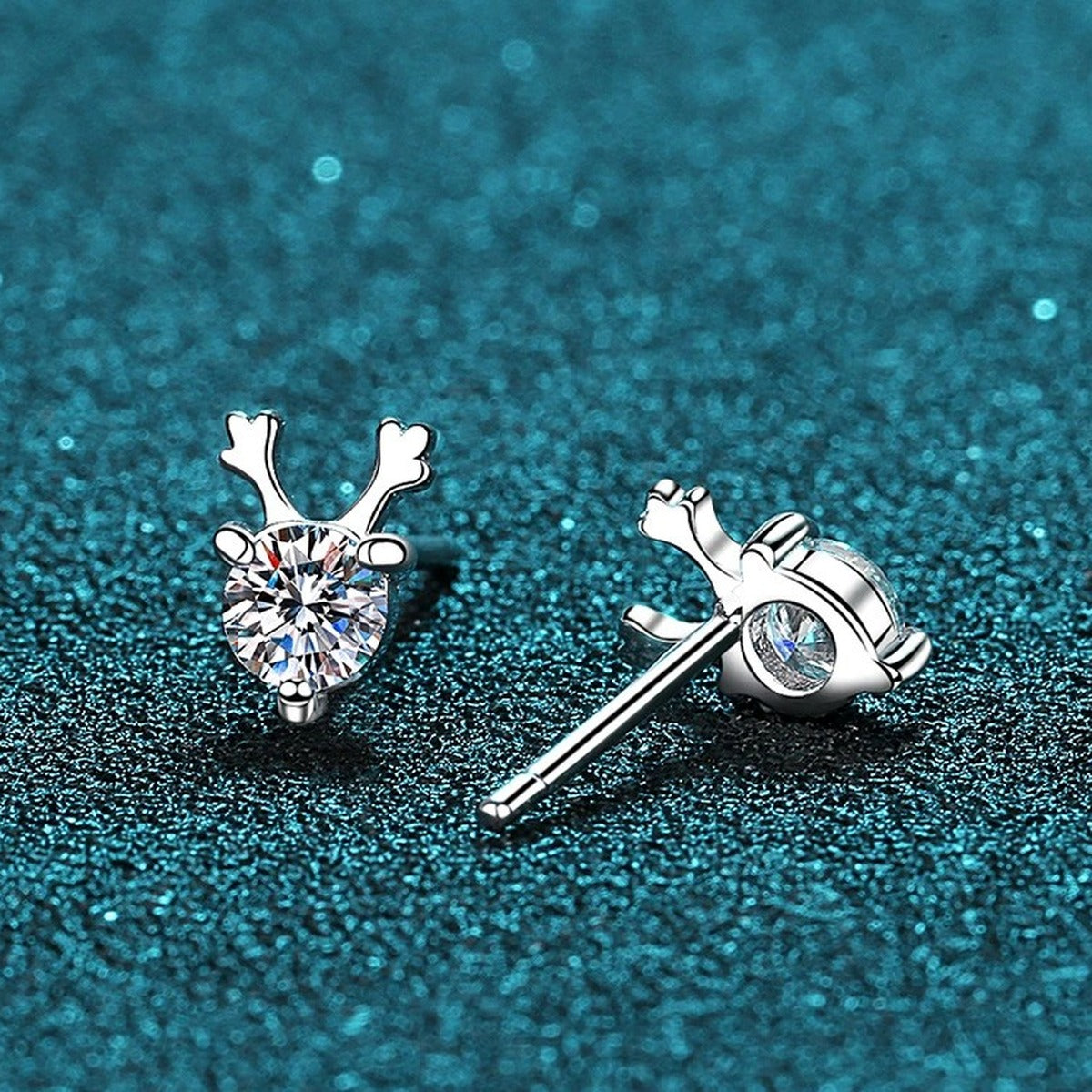 Deer Antler Moissanite Stud Earrings in Rhodium-Plated S925 Sterling Silver on blue-green fabric showing angled setting view