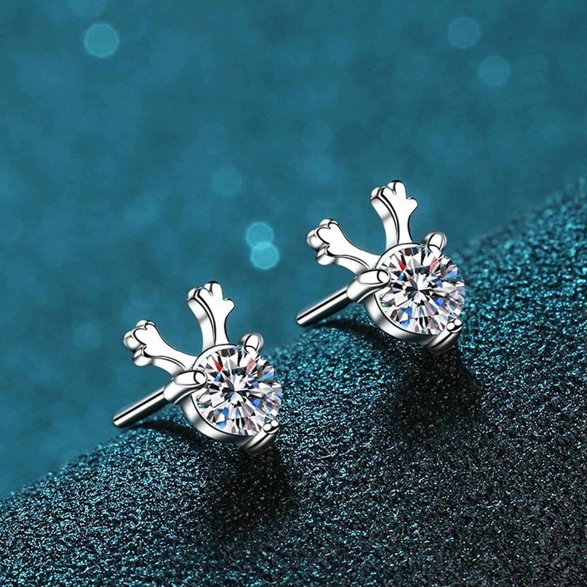 Deer Antler Moissanite Stud Earrings in Rhodium-Plated S925 Sterling Silver on blue-green fabric showing side profile and stone setting