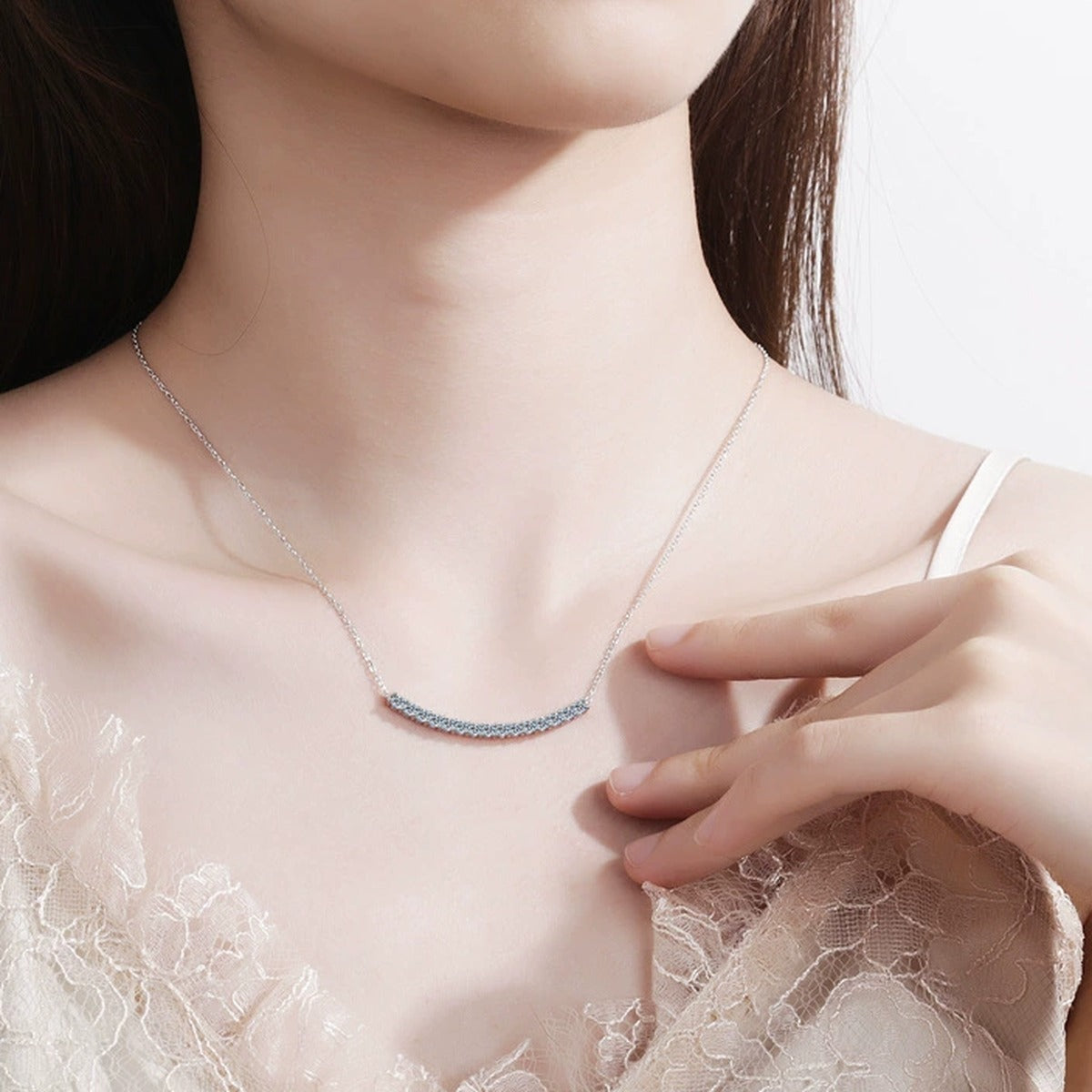 Curved Bar Moissanite Necklace in Rhodium-Plated S925 sterling silver worn on neckline by model showing scale and adjustable chain styling