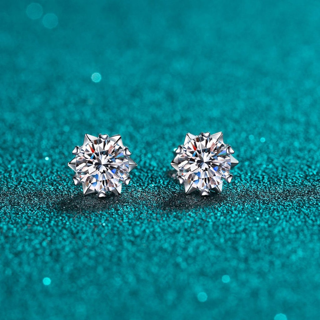 Round Moissanite Stud Earrings in Rhodium-Plated S925 Sterling Silver on blue-green fabric showing angled setting view