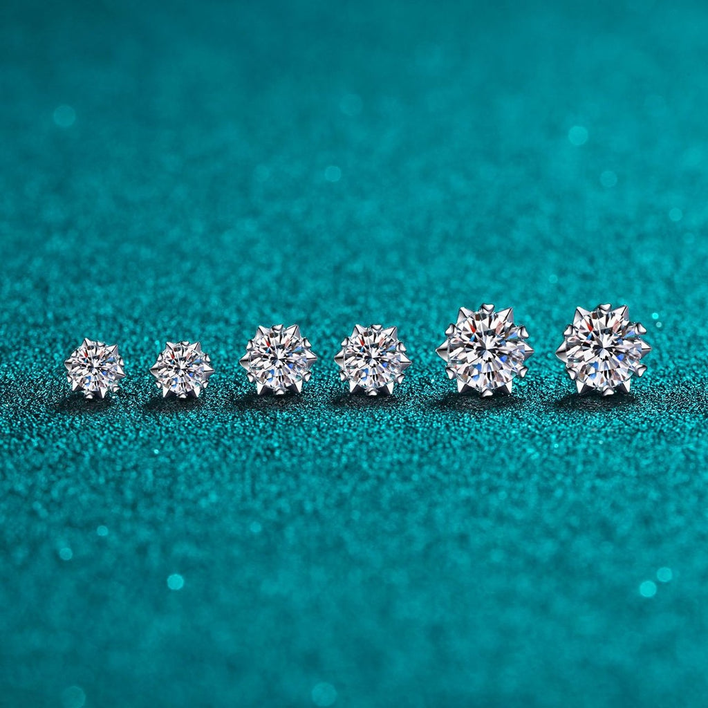 Round Moissanite Stud Earrings in Rhodium-Plated S925 Sterling Silver on blue-green fabric showing side profile and stone setting