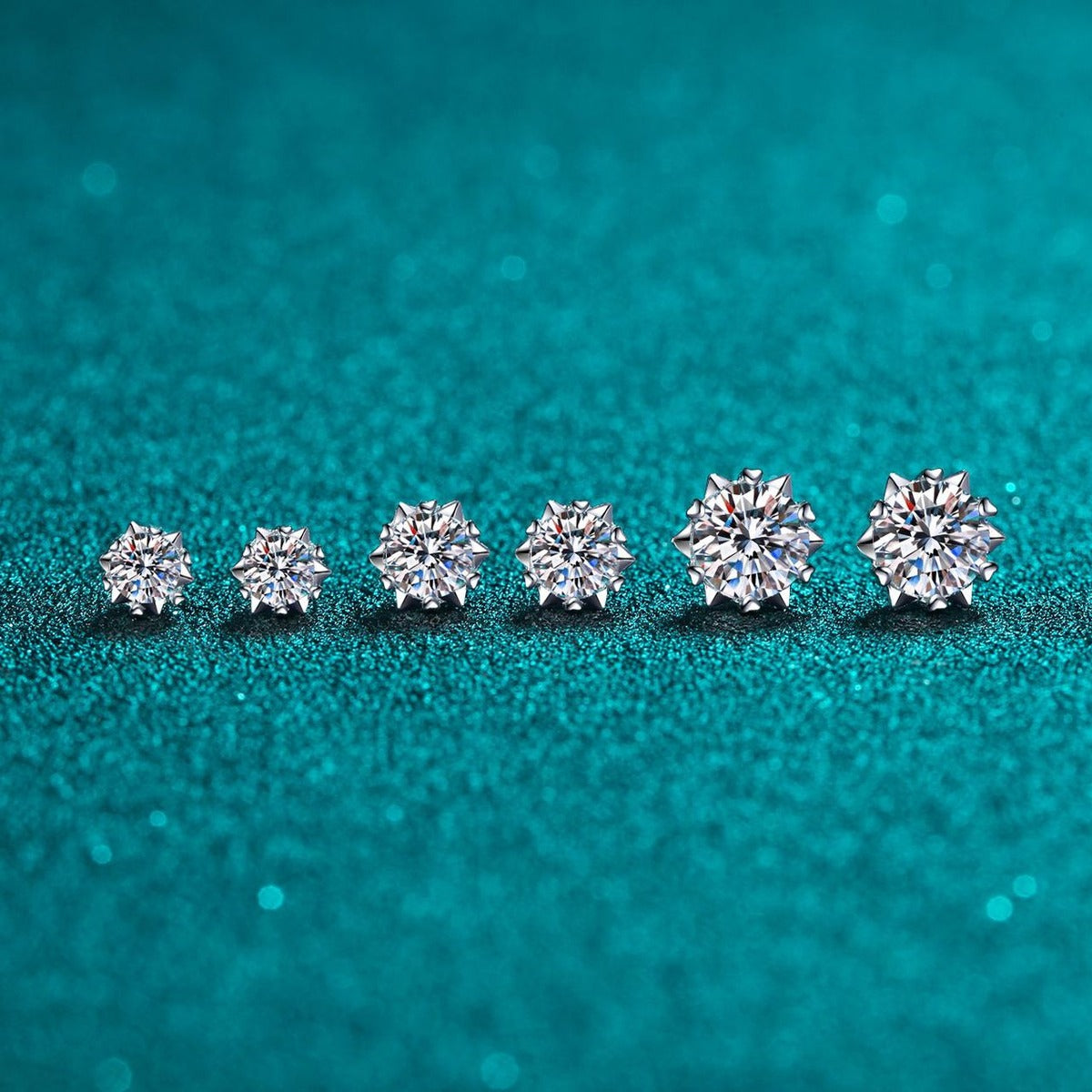Round Moissanite Stud Earrings in Rhodium-Plated S925 Sterling Silver on blue-green fabric showing side profile and stone setting
