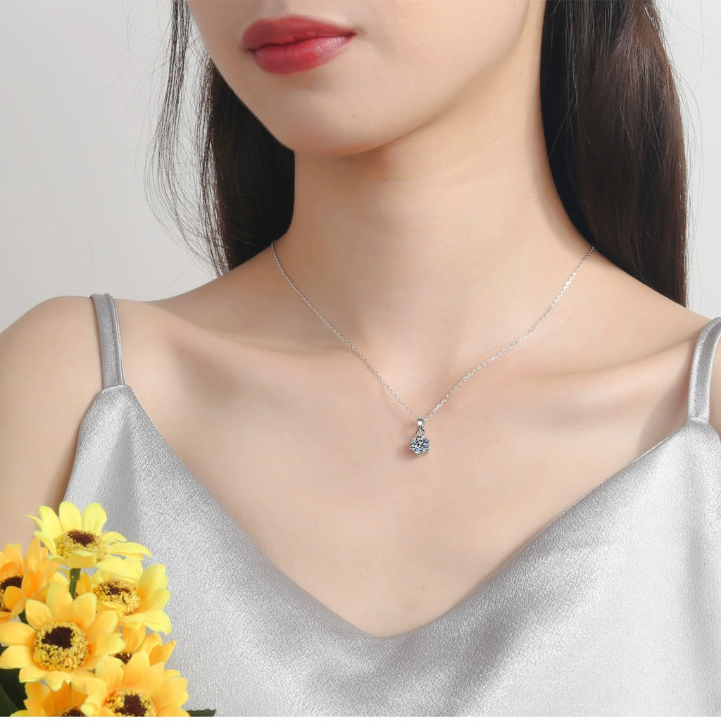Solitaire Moissanite Pendant Necklace in Rhodium-Plated S925 sterling silver worn on neckline by model showing scale and adjustable chain styling