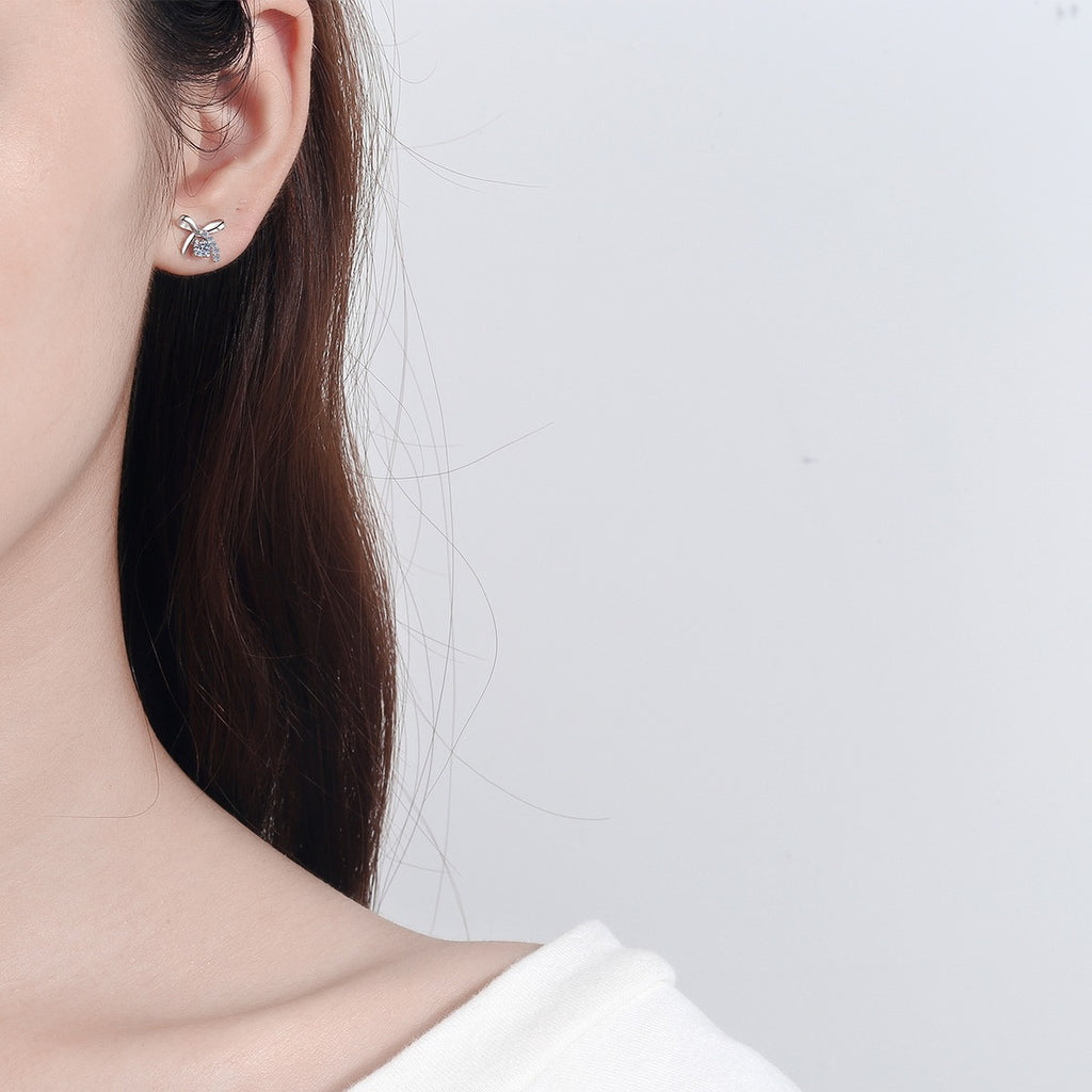 Bow Moissanite Stud Earrings with CZ in Rhodium-Plated S925 Sterling Silver worn on ear by model to show scale, drop length, and everyday styling