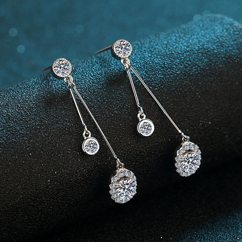 Linear Moissanite Stud Dangle Earrings with CZ in Rhodium-Plated S925 Sterling Silver on blue-green fabric showing side profile and stone setting
