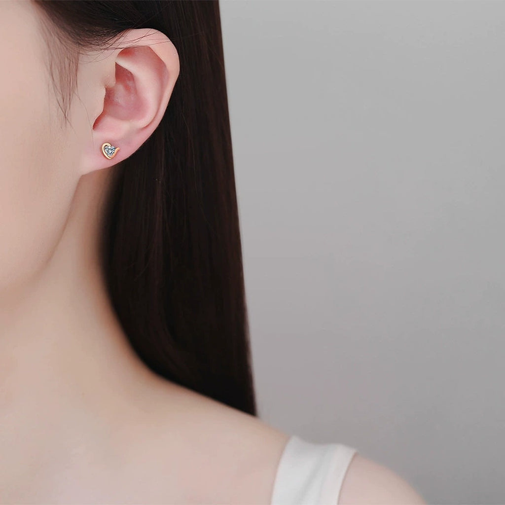 Heart Moissanite Stud Earrings in Champion Gold-Plated S925 sterling silver worn on ear by model showing scale, placement, and stud earrings styling
