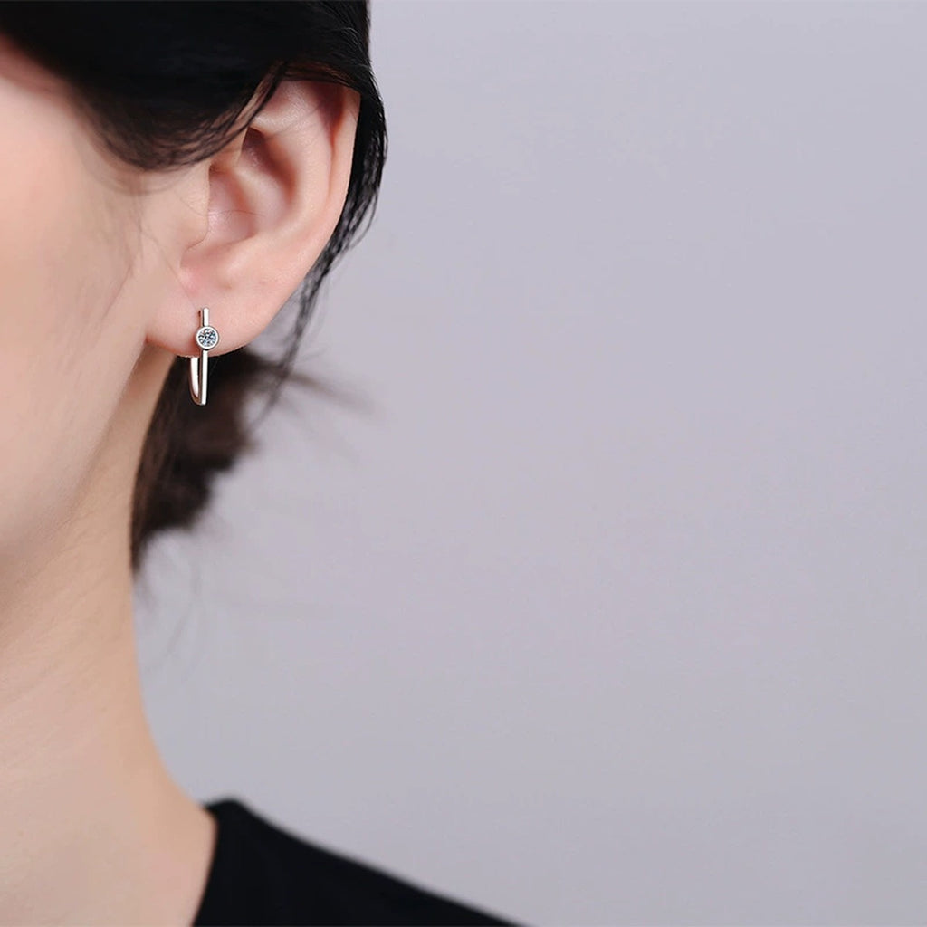 Round Moissanite Stud Drop Earrings in Rhodium-Plated S925 sterling silver worn on ear by model showing scale, placement, and stud earrings styling