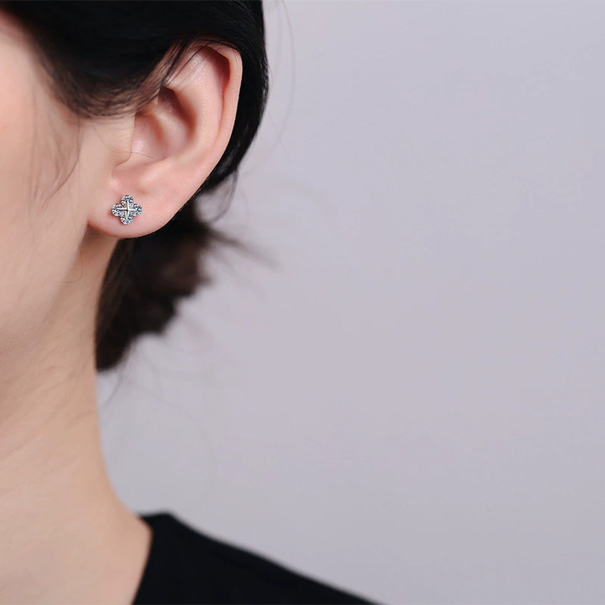 Clover Moissanite Stud Earrings in Rhodium-Plated S925 sterling silver worn on ear by model showing scale, placement, and stud earrings styling