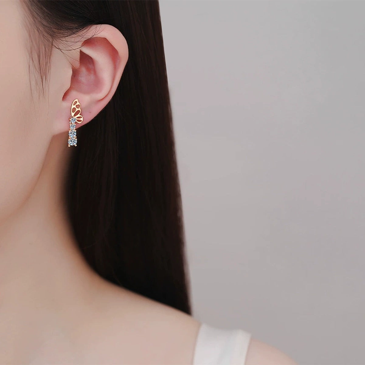 Butterfly Moissanite Stud Drop Earrings in Champion Gold-Plated S925 sterling silver worn on ear by model showing scale, placement, and stud earrings styling