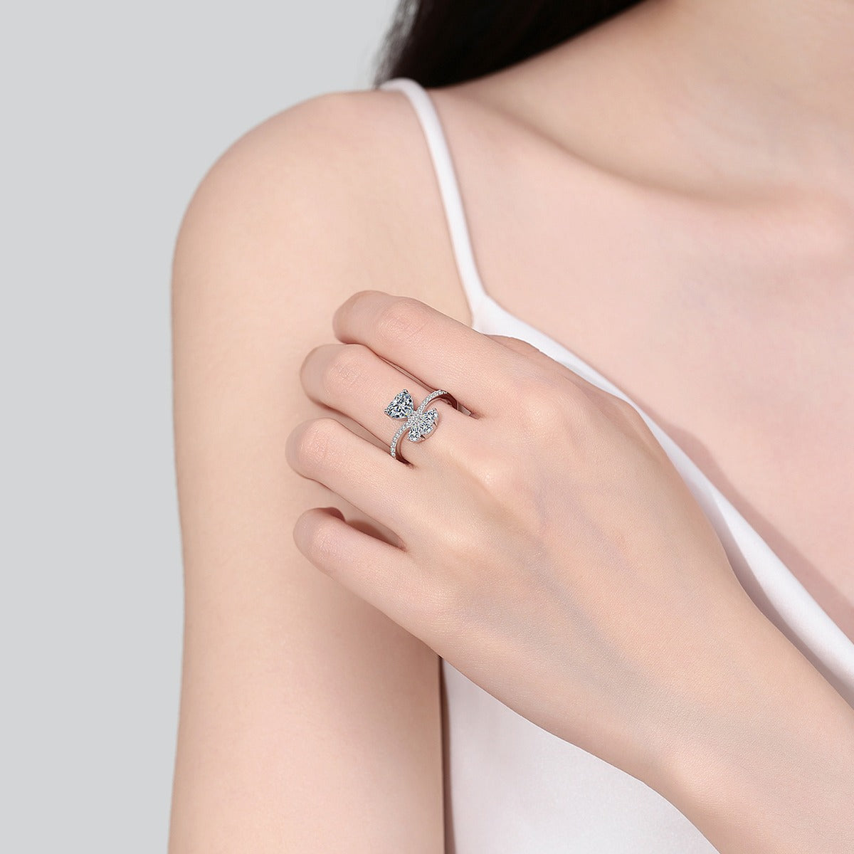 Heart Cut Moissanite Side Stone Engagement Ring with CZ worn on hand to show scale, band width, and ring profile