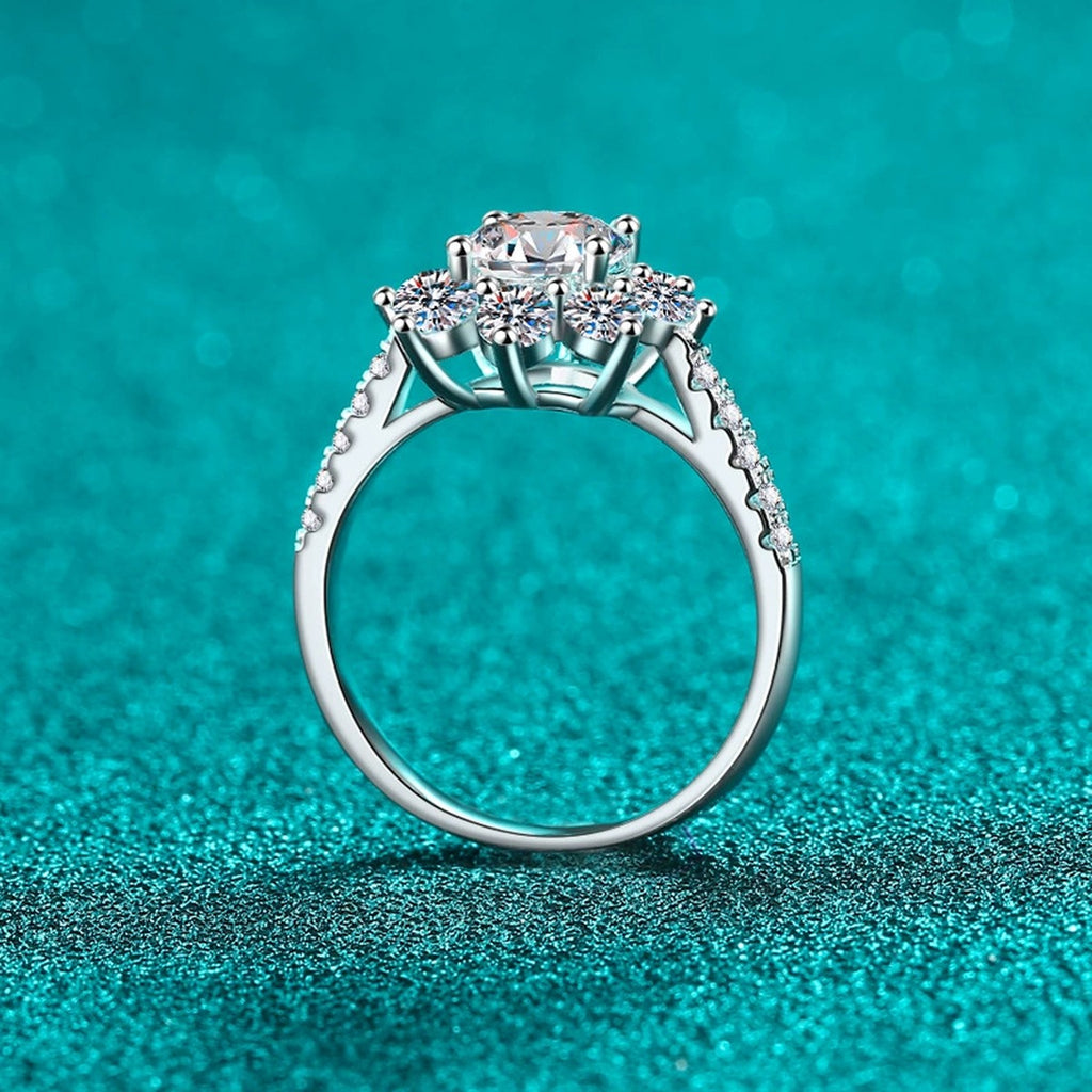 Round Moissanite Side Stone Engagement Ring with CZ in Rhodium-Plated S925 Sterling Silver blue display product photo showing the moissanite setting, stone cut, and band profile