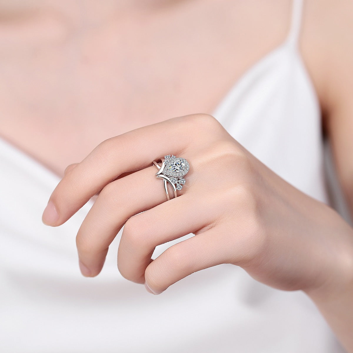 Pear Cut Moissanite Side Stone Engagement Ring with CZ worn on hand to show scale, band width, and ring profile