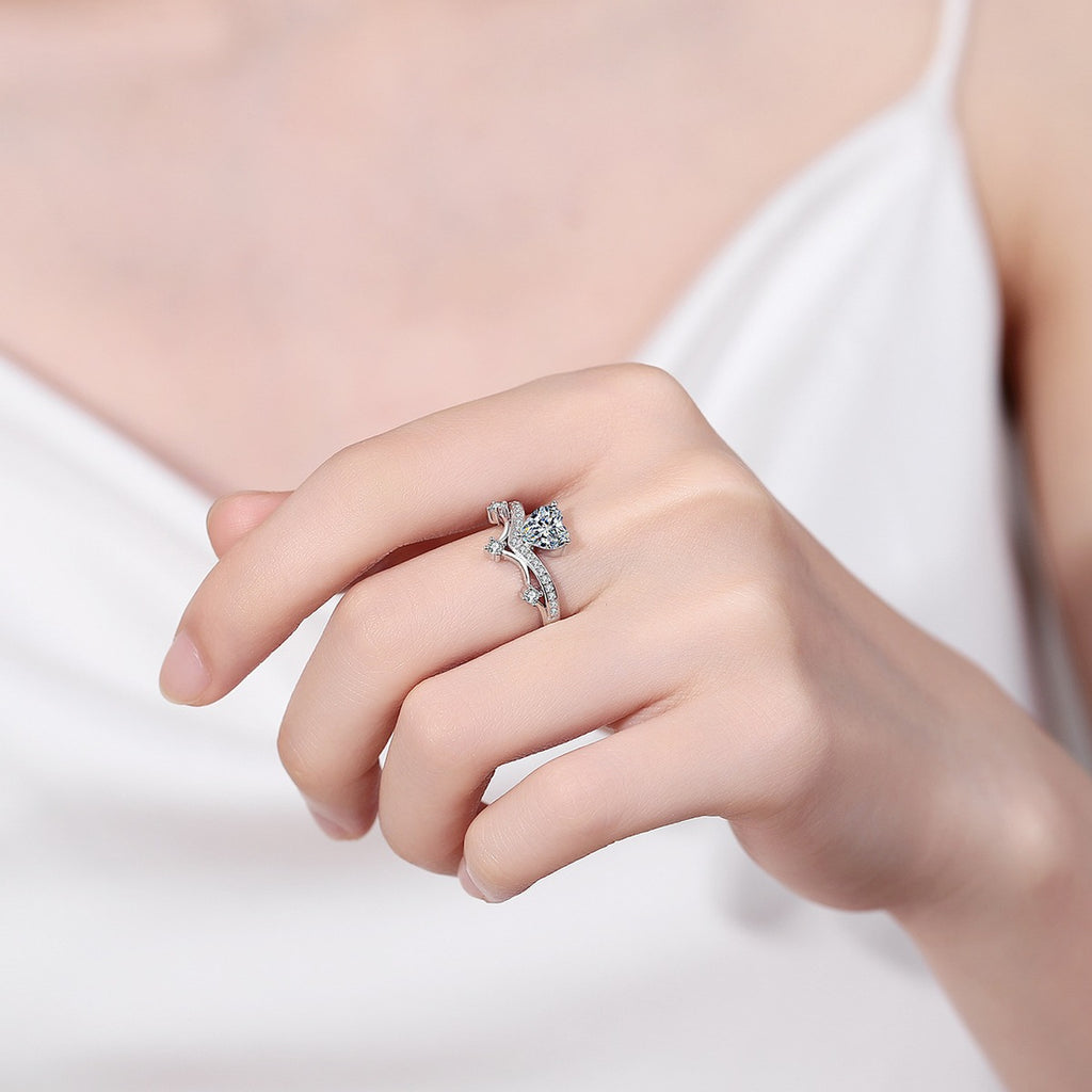 Heart Cut Moissanite Side Stone Engagement Ring with CZ worn on hand to show scale, band width, and ring profile