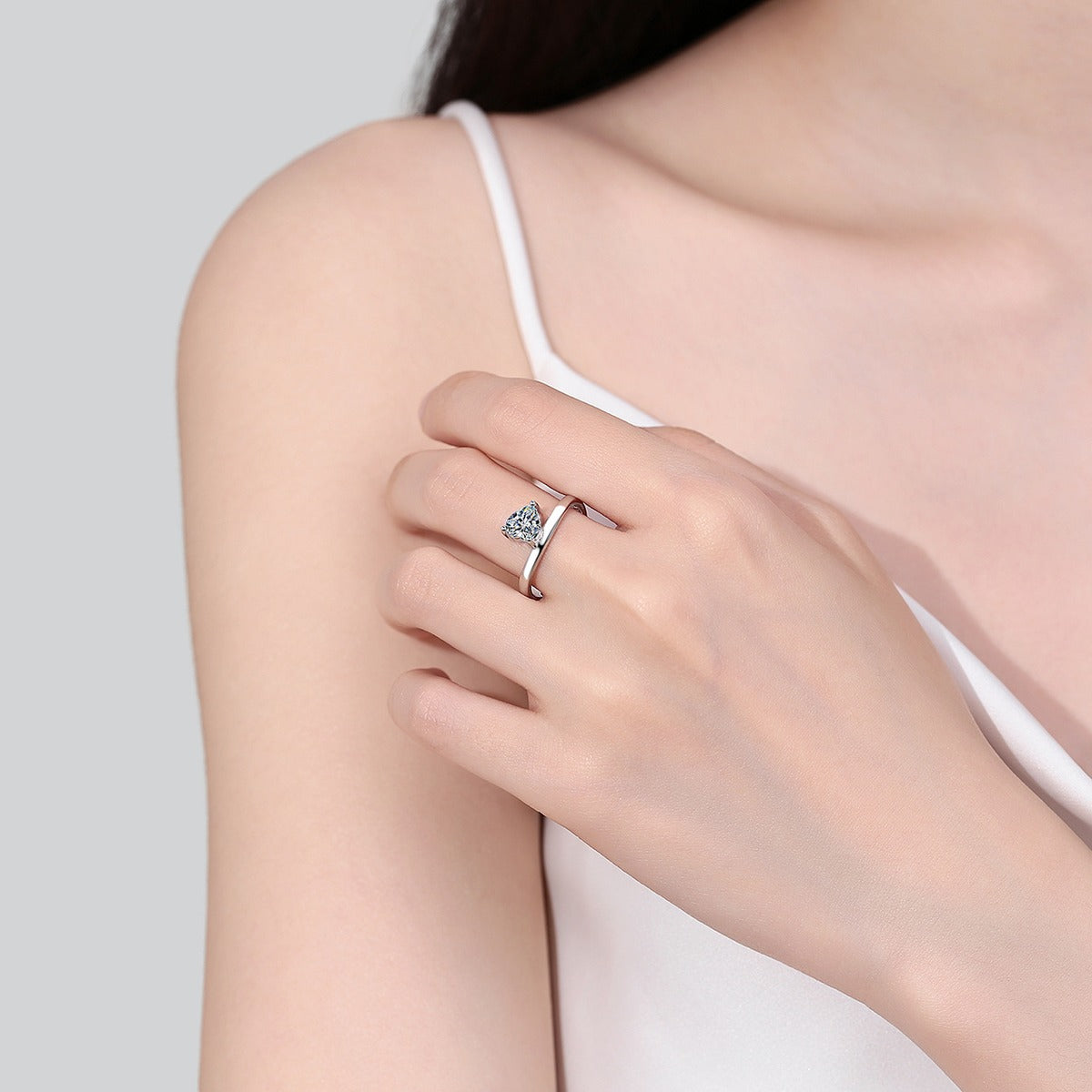 Heart Cut Moissanite Side Stone Engagement Ring worn on hand to show scale, band width, and ring profile