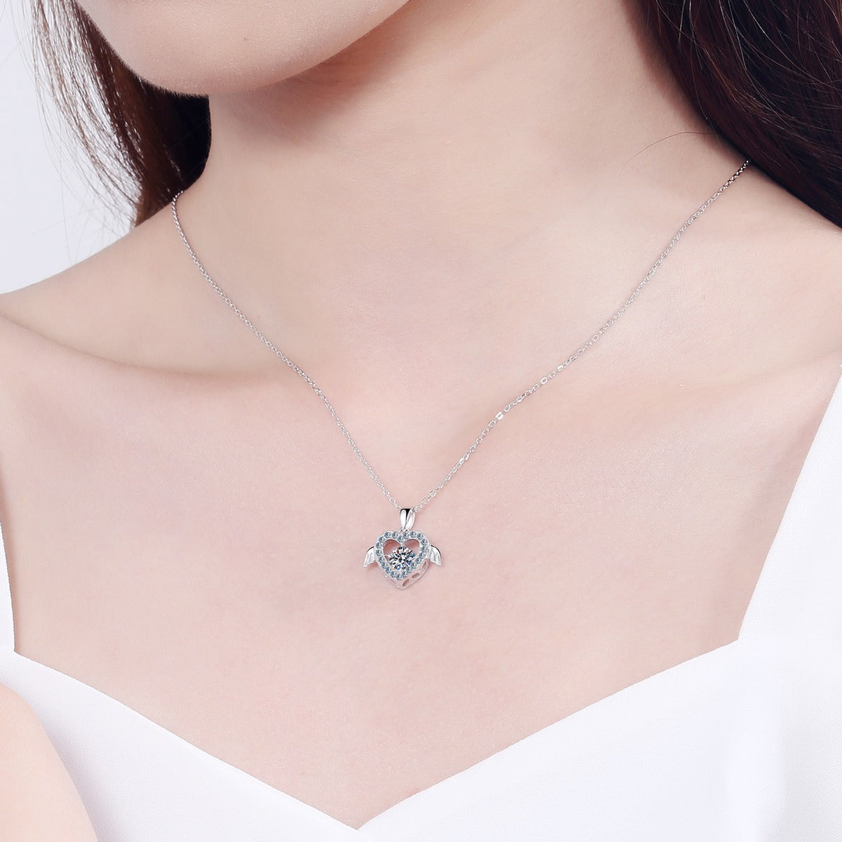 Heart Wing Moissanite Pendant Necklace with CZ in Rhodium-Plated S925 sterling silver worn on neckline by model showing scale and adjustable chain styling