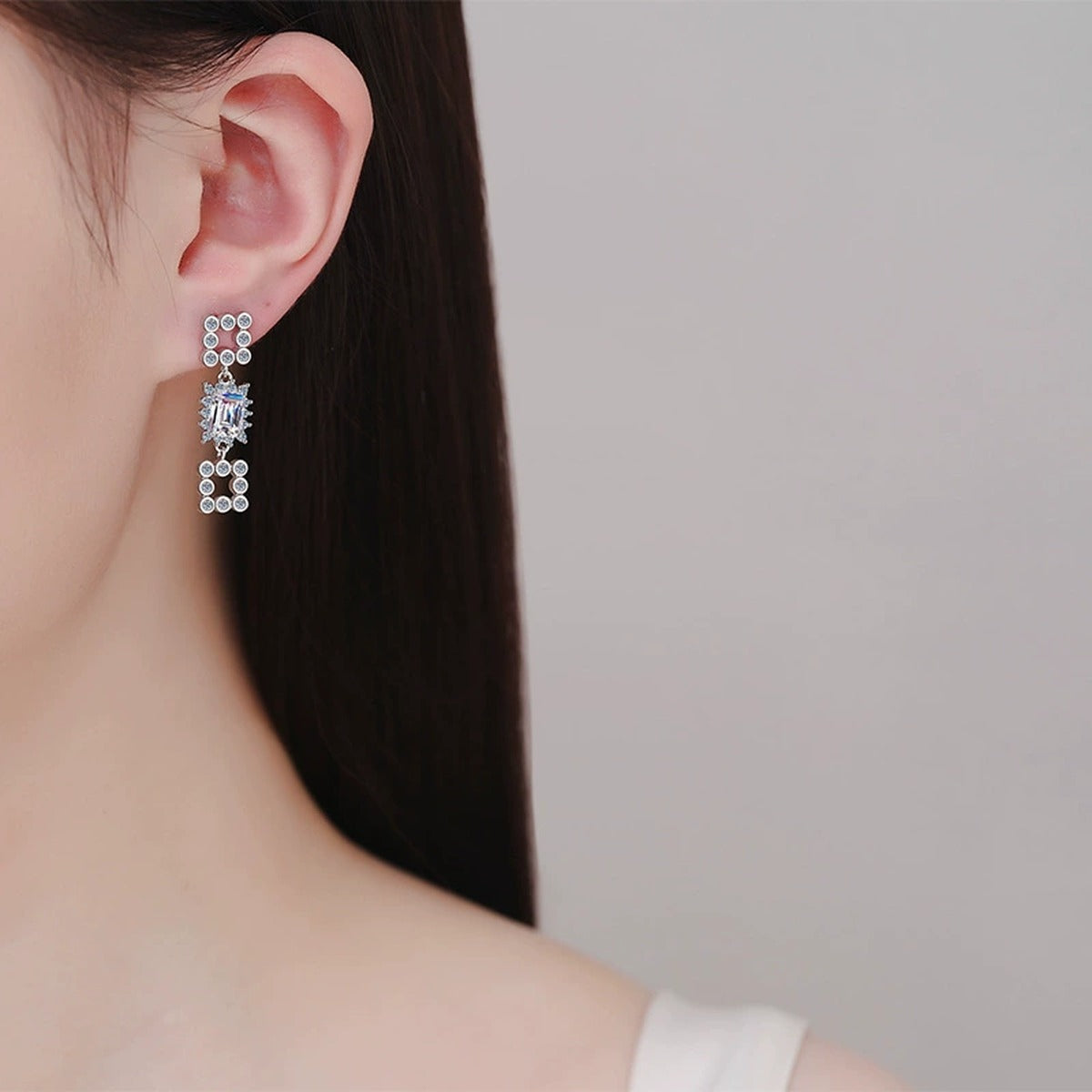 Emerald and Radiant Cut Moissanite Stud Dangle Earrings with CZ in Rhodium-Plated S925 sterling silver worn on ear by model showing scale, placement, and stud dangle earrings styling