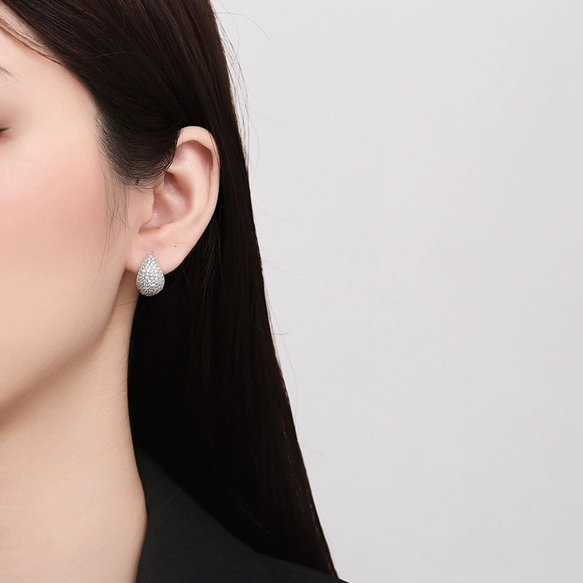 Pave Teardrop Huggie Hoop Earrings in Rhodium-Plated S925 sterling silver worn on ear by model showing scale, placement, and huggie hoop earrings styling