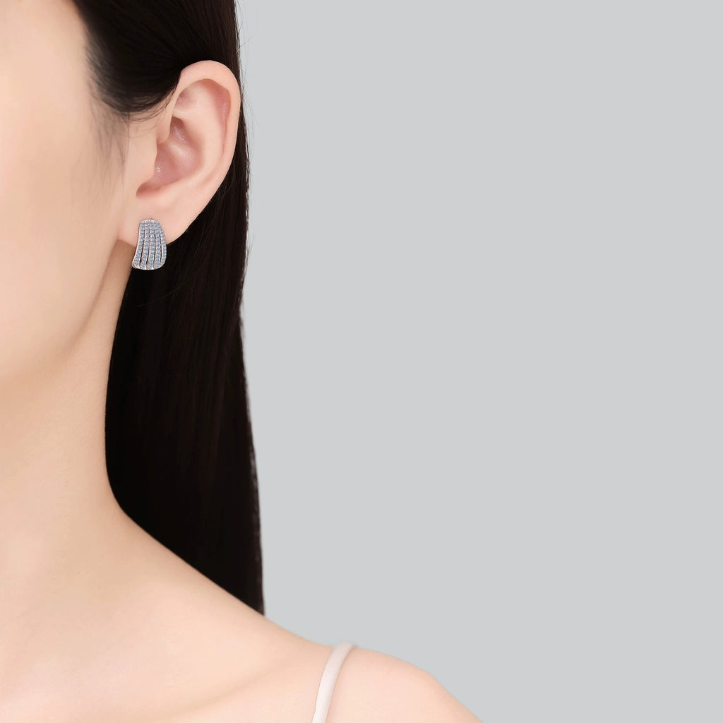 Pave Moissanite Huggie Hoop Earrings in Rhodium-Plated S925 sterling silver worn on ear by model showing scale, placement, and huggie hoop earrings styling