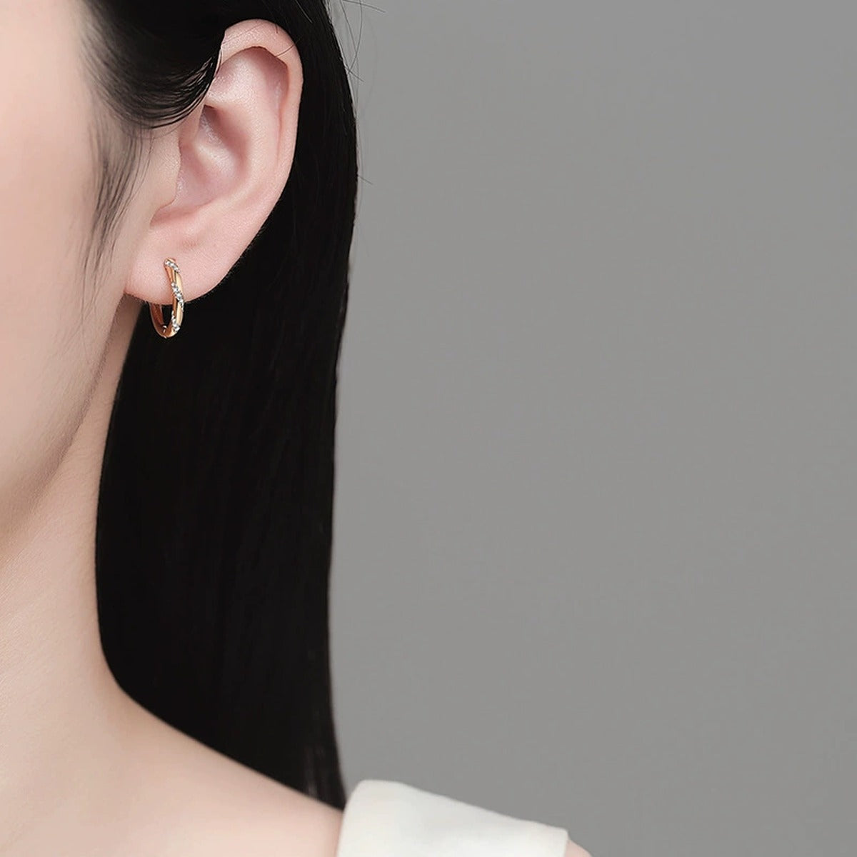 Twisted Pave Moissanite Hoop Earrings in Rhodium-Plated S925 sterling silver worn on ear by model showing scale, placement, and hoop earrings styling