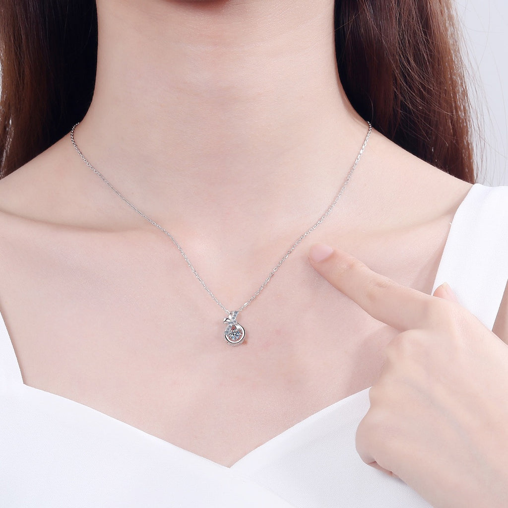 Ribbon Bow Moissanite Pendant Necklace with CZ in Rhodium-Plated S925 sterling silver worn on neckline by model showing scale and adjustable chain styling