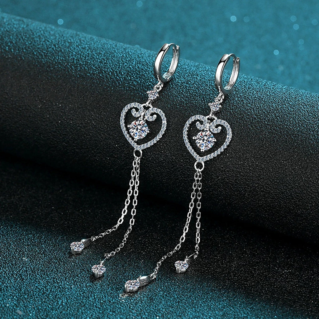 Heart Moissanite Hoop Dangle Earrings with CZ in Rhodium-Plated S925 Sterling Silver on blue-green fabric showing angled setting view
