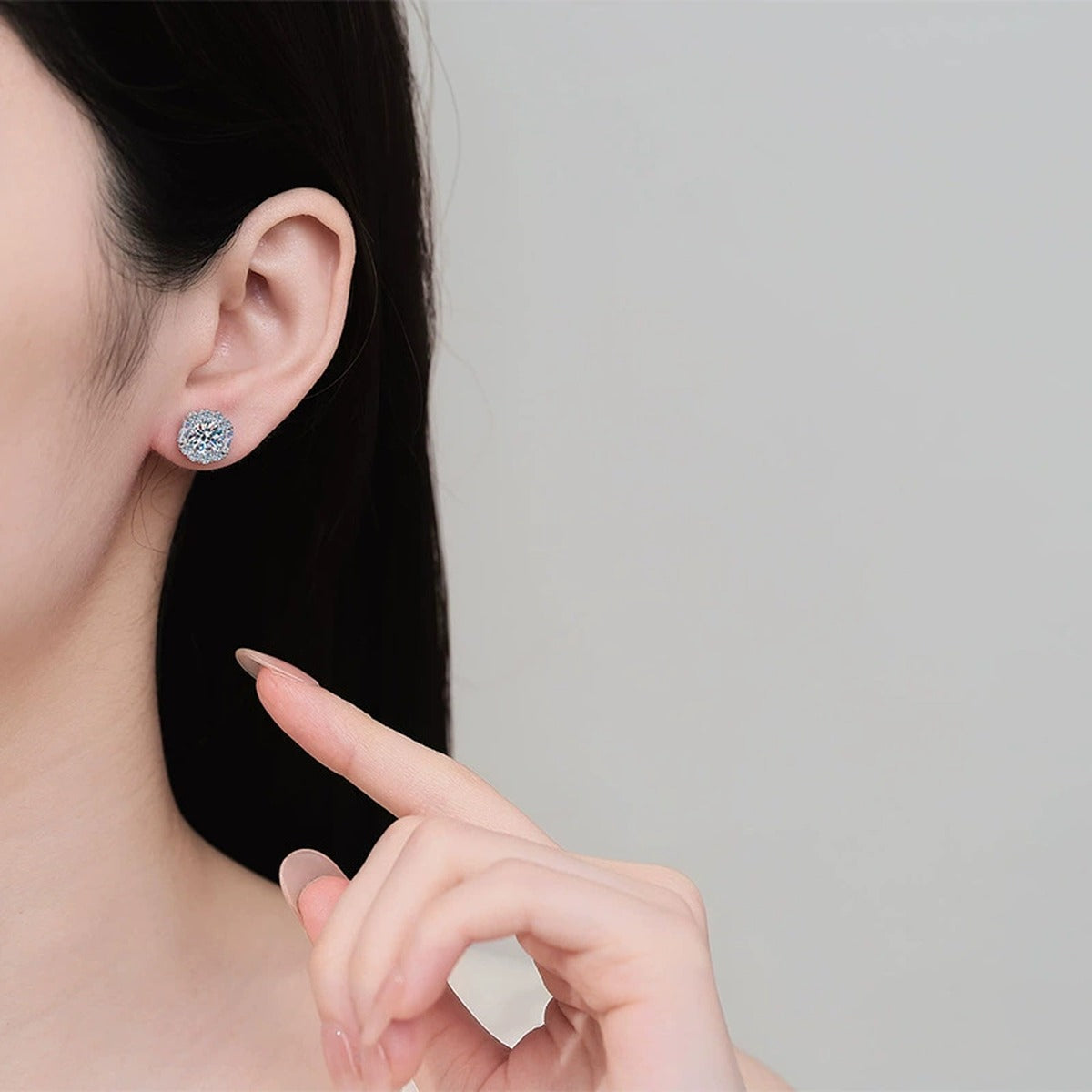 Round Halo Moissanite Stud Earrings with CZ in Rhodium-Plated S925 sterling silver worn on ear by model showing scale, placement, and stud earrings styling