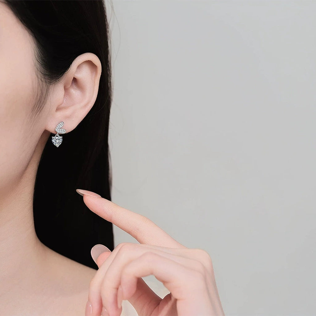 Heart Moissanite Stud Dangle Earrings with CZ in Rhodium-Plated S925 sterling silver worn on ear by model showing scale, placement, and stud dangle earrings styling