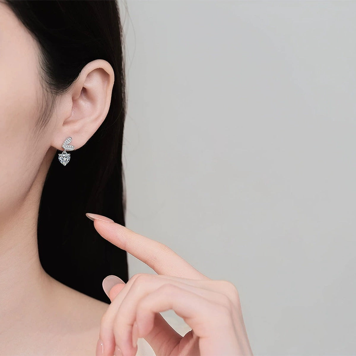Heart Moissanite Stud Dangle Earrings with CZ in Rhodium-Plated S925 sterling silver worn on ear by model showing scale, placement, and stud dangle earrings styling