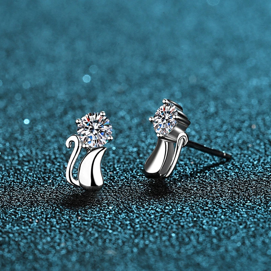 Cat Moissanite Stud Earrings in Rhodium-Plated S925 Sterling Silver on blue-green fabric showing angled setting view