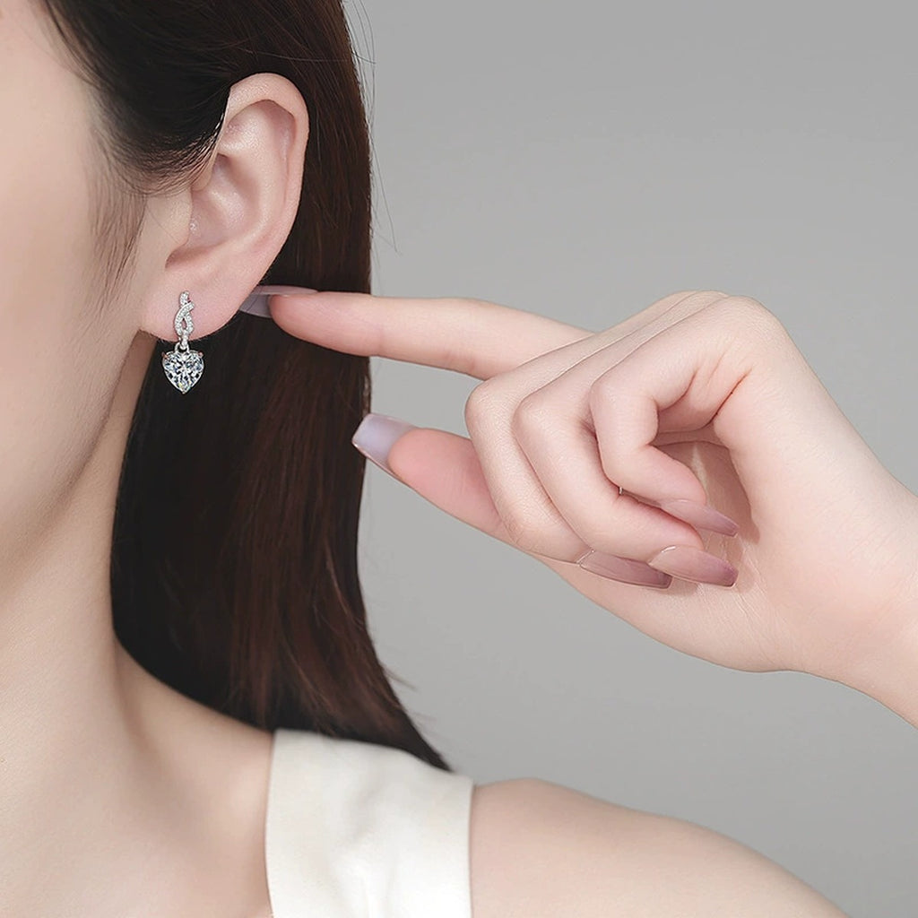 Heart Moissanite Stud Dangle Earrings with CZ in Rhodium-Plated S925 sterling silver worn on ear by model showing scale, placement, and stud dangle earrings styling