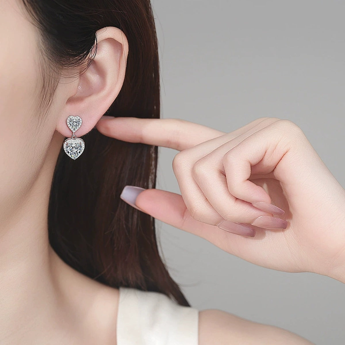 Double Heart Moissanite Stud Dangle Earrings with CZ in Rhodium-Plated S925 sterling silver worn on ear by model showing scale, placement, and stud dangle earrings styling