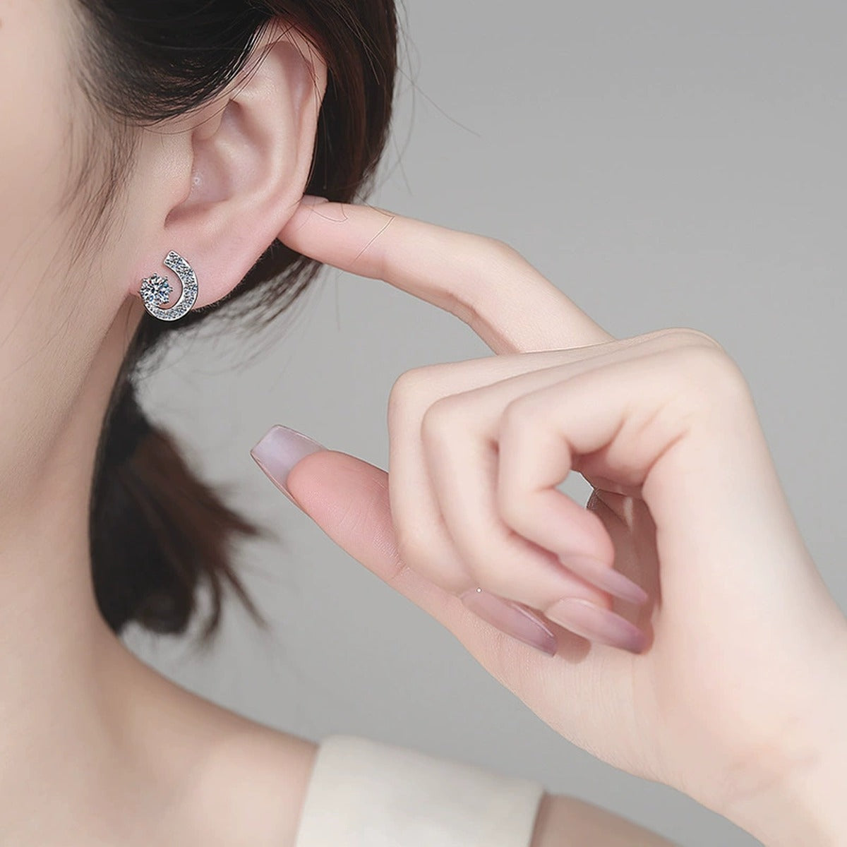 Round Moissanite Stud Earrings with CZ in Rhodium-Plated S925 sterling silver worn on ear by model showing scale, placement, and stud earrings styling