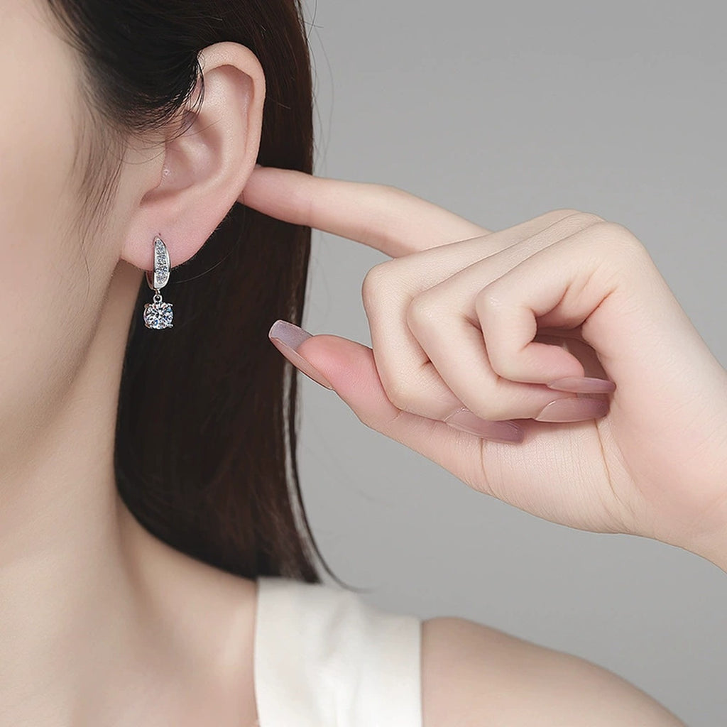 Round Halo Moissanite Hoop Dangle Earrings with CZ in Rhodium-Plated S925 sterling silver worn on ear by model showing scale, placement, and hoop dangle earrings styling
