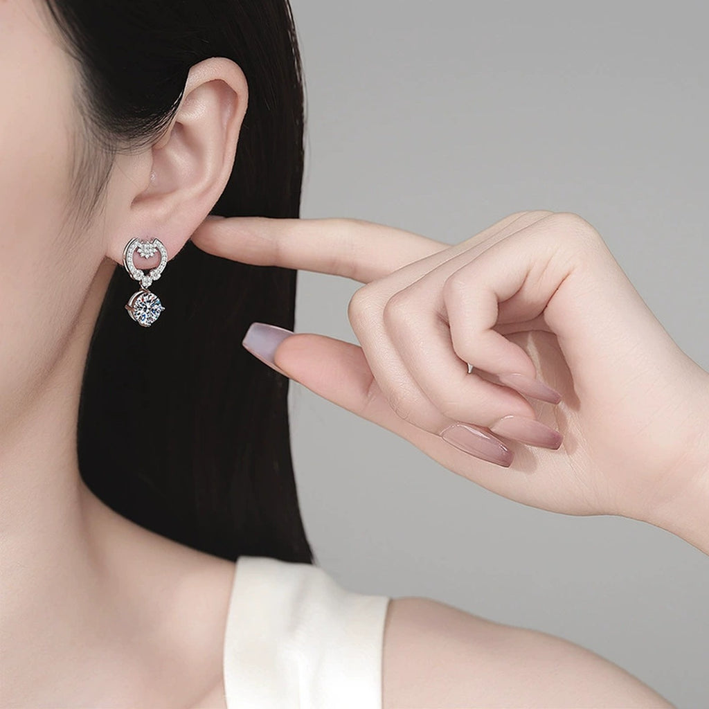 Heart Moissanite Stud Dangle Earrings with CZ in Rhodium-Plated S925 sterling silver worn on ear by model showing scale, placement, and stud dangle earrings styling