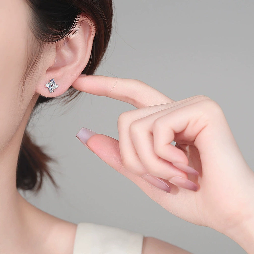 Emerald and Round Moissanite Stud Earrings in Rhodium-Plated S925 sterling silver worn on ear by model showing scale, placement, and stud earrings styling