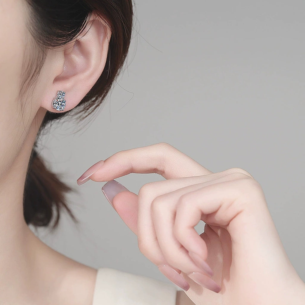 Round Moissanite Stud Earrings in Rhodium-Plated S925 sterling silver worn on ear by model showing scale, placement, and stud earrings styling