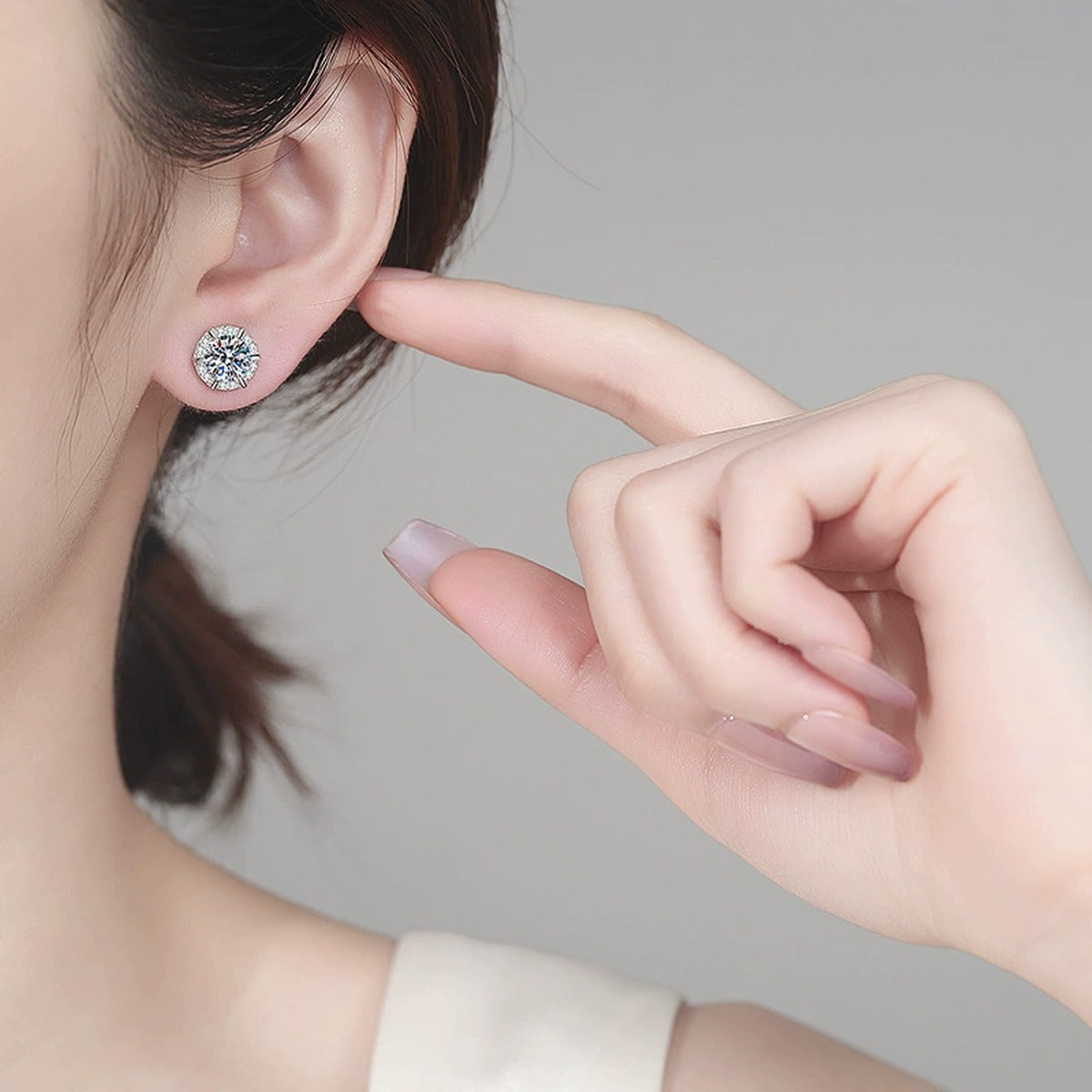 Round Halo Moissanite Stud Earrings with CZ in Rhodium-Plated S925 sterling silver worn on ear by model showing scale, placement, and stud earrings styling