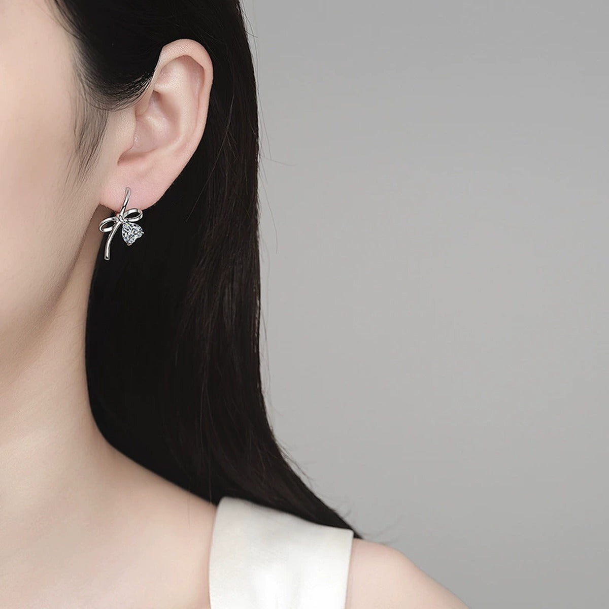 Heart Moissanite Bow Hoop Drop Earrings in Rhodium-Plated S925 sterling silver worn on ear by model showing scale, placement, and hoop drop earrings styling