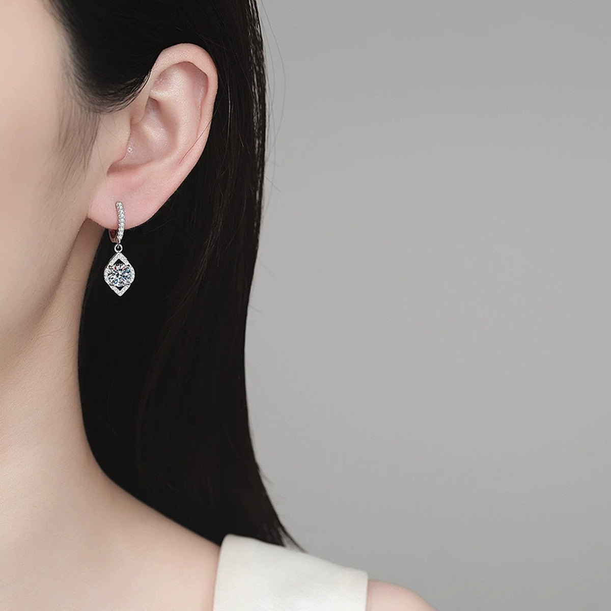 Round Halo Moissanite Hoop Dangle Earrings with CZ in Rhodium-Plated S925 sterling silver worn on ear by model showing scale, placement, and hoop dangle earrings styling